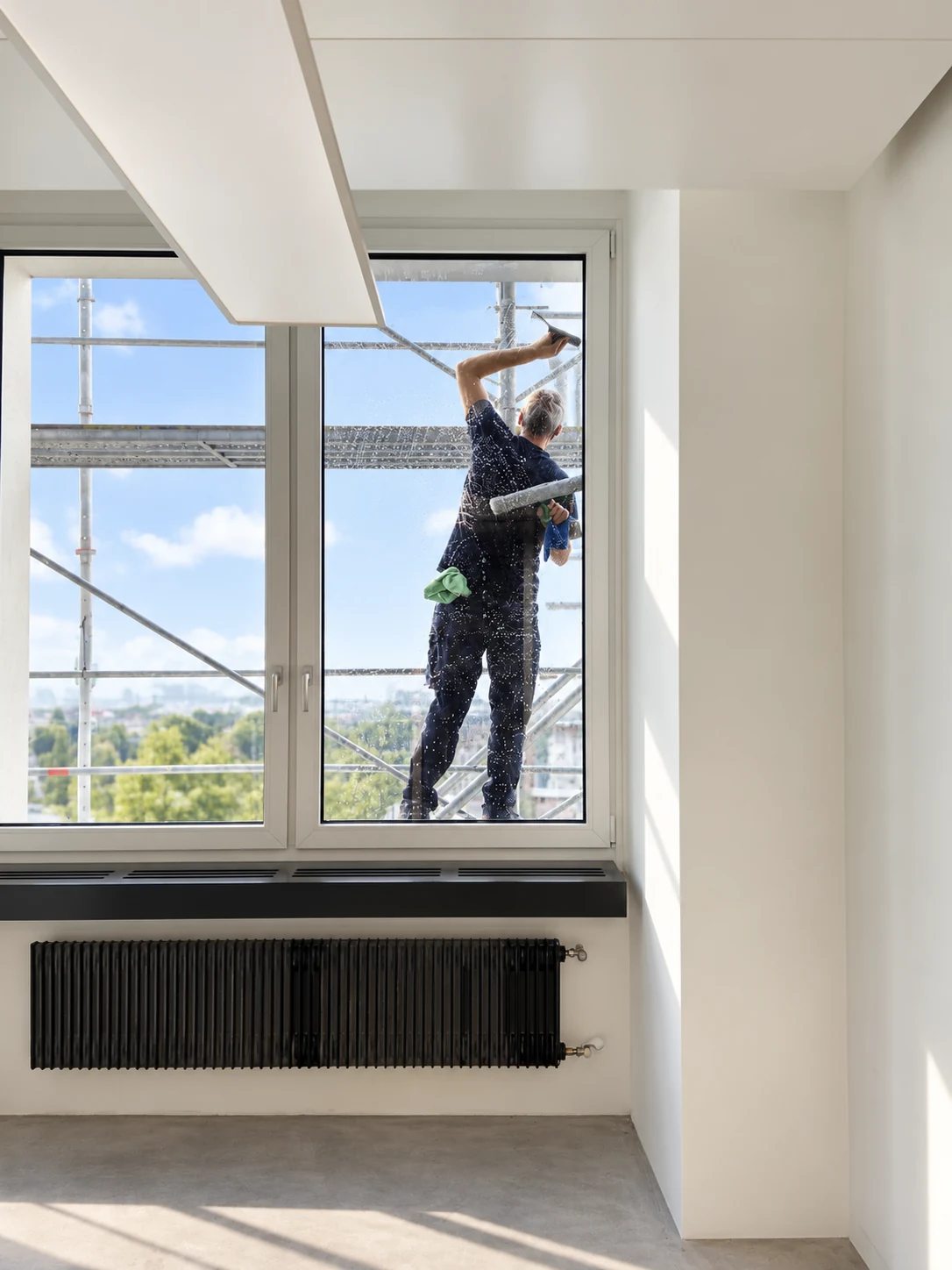 Fensterreinigung während der Baureinigung von einem Baugerüst aus durch Propex in Zürich.