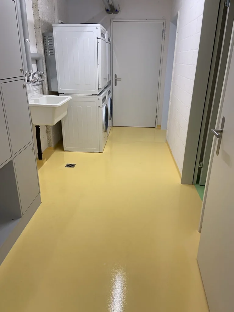 Gemeinschaftswaschraum mit gelbem Boden in der Überbauung Albisbrunn