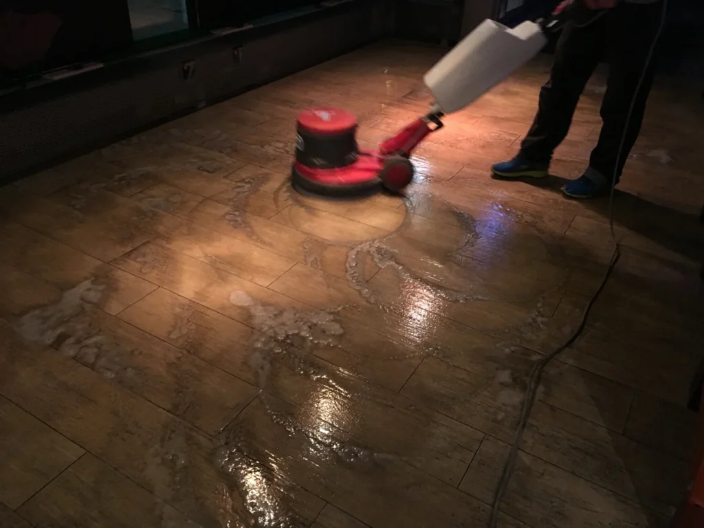 Rote Einscheibenmaschine während der Grundreinigung des Restaurantbodens